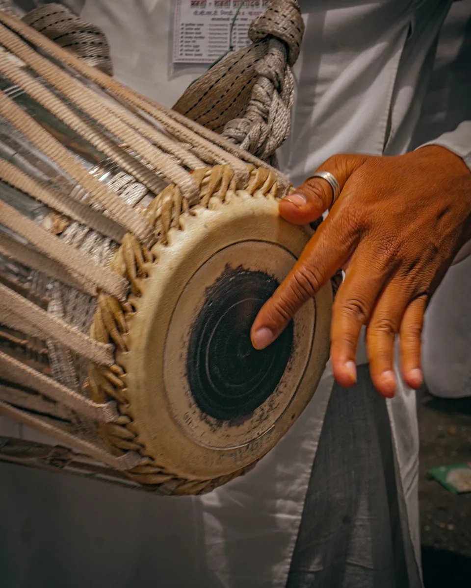 Hands playing a tabla under warm light