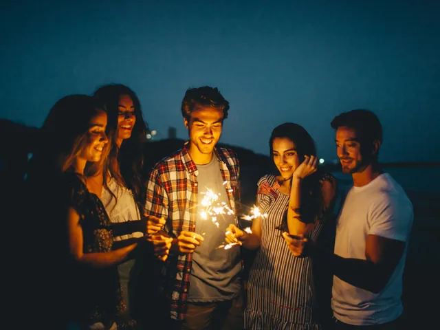 Friends holding sparklers at night