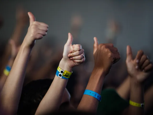 Raised hands wearing event wristbands
